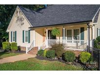 Inviting home featuring a charming front porch with white railings and well-maintained landscaping at 1000 Hunting Ave, Lincolnton, NC 28092