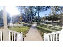 View of the inviting walkway, lush lawn, and black metal fence leading up to this beautiful property at 1000 Hunting Ave, Lincolnton, NC 28092