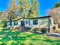 Charming home featuring landscaped yard, dark shutters, and inviting front entrance at 125 Pineville Rd, Statesville, NC 28677