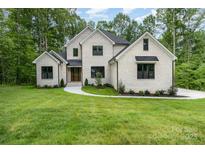 Stunning brick home featuring a manicured lawn and charming walkway at 1025 Readsboro Dr # 11, Mt Ulla, NC 28125