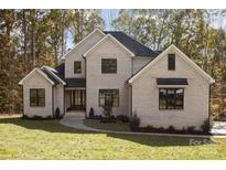 Beautiful two-story brick home featuring a manicured lawn, dark-framed windows, and a welcoming front entrance at 1025 Readsboro Dr # 11, Mt Ulla, NC 28125