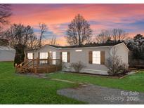 Charming home exterior at sunset with welcoming porch, shutters and landscaped front yard at 1812 Shearers Rd, Davidson, NC 28036