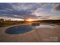 Stunning pool with a captivating sunset view, perfect for relaxation and outdoor enjoyment at 7248 Waterwheel Sw St, Concord, NC 28025