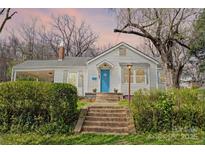 Charming home featuring a bright blue front door, inviting front porch, and well-maintained landscaping at 106 S Inman Ave, Bessemer City, NC 28016