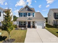 Charming two-story home featuring a well-manicured lawn and a welcoming front porch with brick accents at 1109 Freeman View Dr, Albemarle, NC 28001