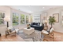 Bright living room featuring hardwood floors, many windows, modern decor, and comfortable seating at 2031 Belmont Terraces Ln # 6, Charlotte, NC 28205