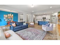 Open-concept living room showcases a blue accent wall, modern furnishings, and a seamless flow into the kitchen at 7059 Duncan Acres Dr, Belmont, NC 28012