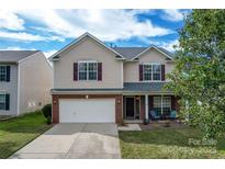 Charming two-story home with red brick accents, attached two-car garage and inviting front porch at 7206 Sandown Ct, Harrisburg, NC 28075
