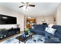 Inviting living room features a large sectional sofa and an entertainment center with a flat-screen TV at 11264 Hyde Pointe Ct, Charlotte, NC 28262