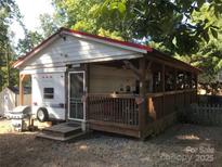 Charming exterior with a covered porch, grill, and American flags at 127 Deer Park Rd # D16, Mount Gilead, NC 27306