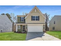 Charming two-story home with a modern design, complemented by a well-manicured lawn and attached garage at 112 Dorian Pl, Troutman, NC 28166