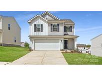 Charming two-story home featuring a two-car garage, gray siding, and a well-manicured lawn at 123 Dorian Pl, Troutman, NC 28166