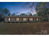 Charming ranch-style home with red shutters, set against a backdrop of trees, perfect for serene living at 539 Rockwell Cir, Rock Hill, SC 29730