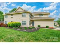 Inviting two-story home showcasing lush landscaping and a manicured lawn at 5832 Amity Springs Dr, Charlotte, NC 28212