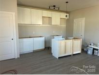 Spacious kitchen featuring white cabinets and modern lighting as construction is underway at 1506 7Th St, Statesville, NC 28677