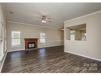 Bright living room features a fireplace, hardwood floors, and a ceiling fan at 14301 Beryl Ct, Pineville, NC 28134