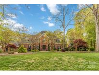 Stately two-story brick home featuring manicured lawn and mature trees at 9723 Sedgefield Dr, Waxhaw, NC 28173