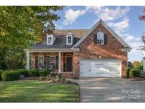 Beautiful brick home featuring a well-maintained lawn, mature landscaping, and a two-car attached garage at 1001 Hatton Ter, Fort Mill, SC 29707