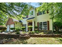 Charming two-story home with brick accents, a manicured lawn, and lush landscaping in the front yard at 3007 Gambrill Falls Dr, Indian Trail, NC 28079