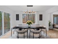 Bright dining room with modern chandelier and wooded view at 3216 High Ridge Rd, Charlotte, NC 28270