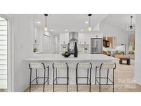 Modern white kitchen with stainless steel appliances and large island at 3216 High Ridge Rd, Charlotte, NC 28270