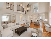 Bright, open living room featuring hardwood floors, modern decor, and a view into the spacious kitchen at 501 River Oaks Ln, Charlotte, NC 28226