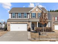 Charming two-story home featuring a brick facade, well-maintained landscaping, and an attached two-car garage at 5011 Tatton Ln, Indian Land, SC 29707