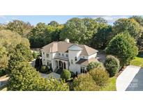 Stunning aerial view of a luxury home with lush landscaping and mature trees at 8703 Kentucky Derby Dr, Waxhaw, NC 28173