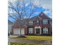 Brick two-story house with a three-car garage and landscaped lawn at 13123 Ashley Meadow Dr, Charlotte, NC 28213