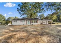 Charming renovated ranch home with white brick, craftsman-style shutters, and a lovely light blue front door at 3503 Linwood Rd, Gastonia, NC 28052