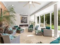 Bright sunroom with large windows, fireplace, neutral tones, and cozy seating arrangement at 2723 Providence Pine Ln, Charlotte, NC 28270