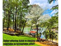 Stunning waterfront backyard with lush greenery, pier, and serene lake views at 377 Riverwood Rd, Mooresville, NC 28117