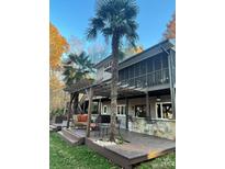 Inviting outdoor space with a wooden deck, pergola, bar, and seating for relaxation and entertaining at 377 Riverwood Rd, Mooresville, NC 28117