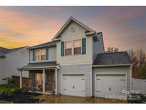 Charming two-story home features a two car garage, blue shutters and vinyl siding at 1176 Whitehall Hill Rd, York, SC 29745