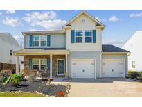 Charming two-story home features a two car garage, blue shutters and vinyl siding at 1176 Whitehall Hill Rd, York, SC 29745