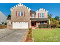 Two-story brick home with a large yard and attached garage at 124 Kendrick Farm Dr, Mount Holly, NC 28120