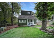 Charming green home with a manicured lawn, mature trees and a welcoming front porch at 26034 Misty Way Dr, Fort Mill, SC 29708