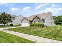 Charming home featuring manicured lawn, a two-car garage, brick accents, and lovely landscaping at 135 Anastasia Ln, Lincolnton, NC 28092