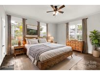 Bright and airy main bedroom featuring hardwood floors, a ceiling fan, and natural light from surrounding windows at 305 N White St, Lancaster, SC 29720