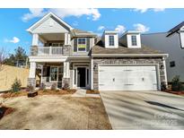 Two-story house with stone accents, a large garage, and a balcony at 5226 Verona Rd # 81, Charlotte, NC 28213