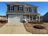 Two-story house with gray siding, white garage door, and landscaping at 11933 Cabera Ln, Midland, NC 28107