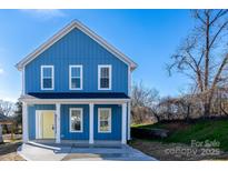 Charming blue two-story home with a welcoming front porch and a bright yellow front door at 518 Herms Ave, Mount Holly, NC 28120