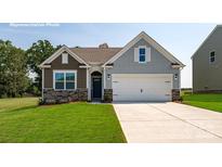 Charming home exterior with stone accents, neat landscaping, and a two-car garage on a sunny day at 3865 Maxwell Henry Nw Ln, Conover, NC 28613