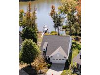 Aerial view of a charming home with a gray roof, complemented by a private dock and tree lined waterfront at 31226 Cove View Ct, Lancaster, SC 29720