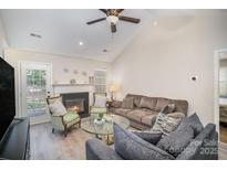 Inviting living room with a cozy fireplace, vaulted ceiling, ceiling fan and comfortable furnishings at 9200 Forest Green Dr, Charlotte, NC 28227