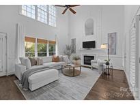 Spacious living room with fireplace, high ceiling, large windows, and comfortable seating at 5303 Shasta Hill Ct, Charlotte, NC 28211