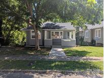 Charming gray home with covered front porch and mature shade tree, offering curb appeal at 602 W Council St, Salisbury, NC 28144