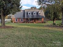 Charming brick home with a well-manicured lawn and inviting front porch at 2304 Fox Hunt Dr, Monroe, NC 28110