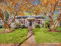 Charming home with lush front lawn, red shutters, sidewalk, and mature trees with fall foliage at 412 Keels Ave, Rock Hill, SC 29730