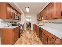 Traditional kitchen with warm wood cabinetry, stainless steel appliances, and light countertops at 10933 Hunter Trail Ln, Charlotte, NC 28226